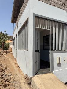 a white building with an open garage door at Casa Amélia in Cidade Velha