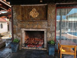 a stone fireplace with a bunch of food in it at Къща за гости Бащин дом in Apriltsi