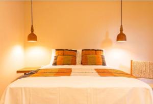a bedroom with a bed with orange and yellow pillows at Casa Revoada BG PI in Barra Grande