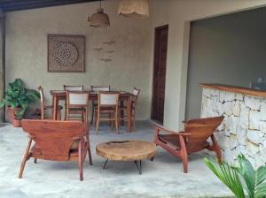 a dining room with chairs and a table and a stone fireplace at Casa Revoada BG PI in Barra Grande