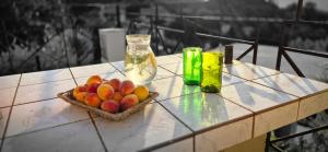 a table with a bowl of fruit and a bottle at Mary's House in Vourliótai