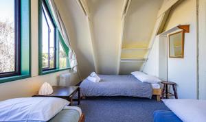 a room with two beds and two windows at Adventure Base in Ohakune