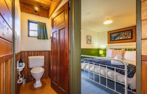 a small bedroom with a bed and a toilet at Adventure Base in Ohakune