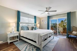 a bedroom with a bed and a balcony at Beach You To It in Anna Maria