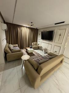 a living room with two couches and a tv at A Spacious, Stylish, and Perfectly Located in the heart of Cairo - Two bedroom Condo! in Cairo