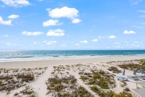 an aerial view of a beach with chairs and the ocean at Beachfront Waves in Bradenton Beach
