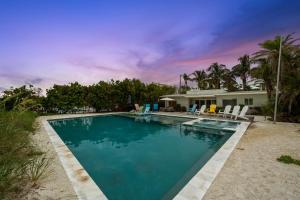a swimming pool in front of a house at Beachfront Bungalow in Holmes Beach