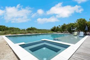 a large swimming pool with a wooden deck at Beachfront Bungalow in Holmes Beach