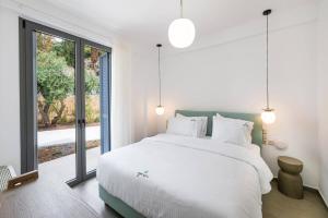 a bedroom with a large bed and a large window at Villa Cypressa by Villa Plus in Kalamitsi +17 photos
