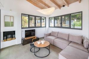 a living room with a couch and a table at Villa Cypressa by Villa Plus in Kalamitsi