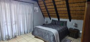 a bedroom with a bed and a large window at Eagles Nest in Rustenburg