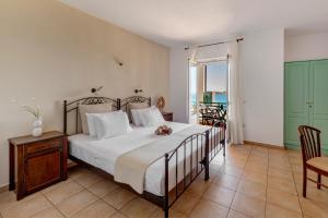 ein Schlafzimmer mit einem Bett, einem Tisch und Stühlen in der Unterkunft Brazzera Hotel in Finikas