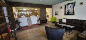 a living room with a leather couch and a green chair at Pension Melsungen in Melsungen