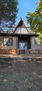 a house with a roof with a bench in front of it at Eagles Nest in Rustenburg