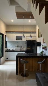 a kitchen with a counter and two bar stools at Villa Adela Sky Land Malang in Karangploso