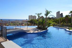 a large swimming pool with a bridge in a city at Benidorm Luxury Residential in Benidorm