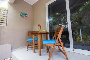 a table and chairs on a porch with a window at Hibiscus Beach House in Willemstad