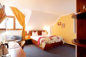 a hotel room with a bed and a desk at Hotel am Katharinenholz in Potsdam