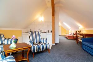 a living room with blue chairs and a kitchen at Hotel am Katharinenholz in Potsdam