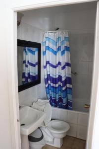 a bathroom with a sink and a toilet and a shower curtain at Hotel Montecatini SPA in Copiapó