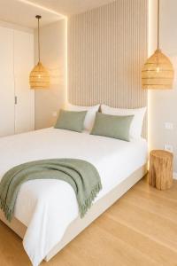 a bedroom with a white bed with a green blanket on it at Beograd na vodi-Belgrade Waterfront in Belgrade