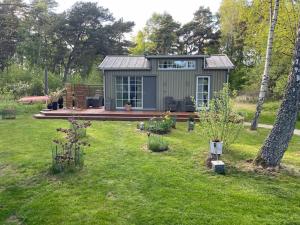 ein winziges Haus mitten in einem Garten in der Unterkunft Hamngardi in Stånga