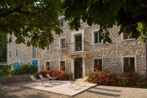 a stone building with chairs in front of it at Dormire alla Ruota in Negrar