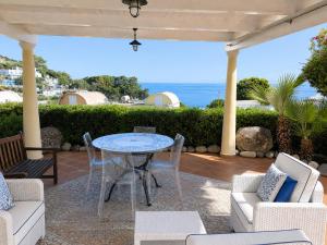 a patio with a table and chairs and the ocean at Maridea - Villetta Brezza Marina in Ponza