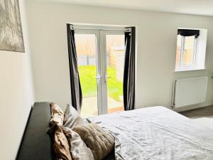 a bedroom with a bed and a sliding glass door at Ansari Palace in Worting