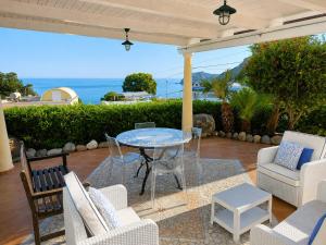 a patio with a table and chairs and the ocean at Maridea - Villetta Brezza Marina in Ponza
