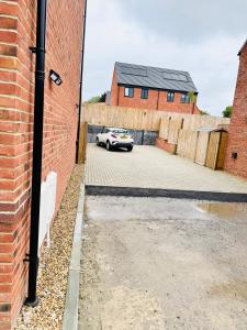 a car parked in a parking lot next to a brick building at Ansari Palace in Worting