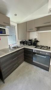 a kitchen with a sink and a stove top oven at Numero 281 in La Tremblade
