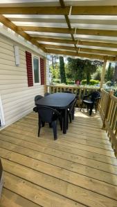 a patio with a table and chairs on a wooden deck at Numero 281 in La Tremblade
