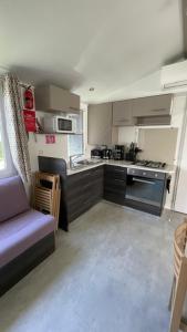 a kitchen with a purple couch in a room at Numero 281 in La Tremblade