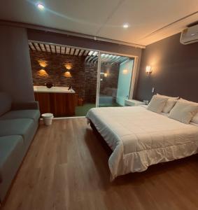 a bedroom with a large bed and a couch at Casa ORO VERDE in San Luis