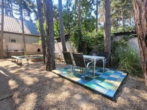 a table and chairs in a yard with trees at VilLa AdeLe in Siófok