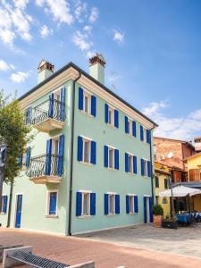 a large blue building with blue windows and balconies at Casa del Marinaio - Agenzia Cocal in Caorle