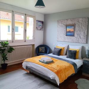 a bedroom with a large bed with an orange blanket at Pearly Maison Central Ruffec in Ruffec