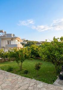 a yard with trees in front of a house at Villa Murataj in Ksamil