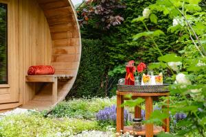 a table in a garden with a bench and flowers at B&Biotope in Heusden