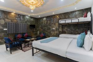 a bedroom with two beds and a stone wall at Emperor Palace Heritage Villa Udaipur in Udaipur
