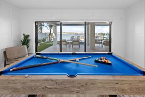 a blue pool table with bats on top of it at Big Nauti in Bradenton Beach