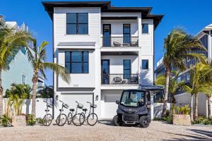 a golf cart parked in front of a building with bikes at Big Nauti in Bradenton Beach