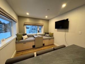 a living room with a couch and a flat screen tv at Opulence Suite-Luxury New Build with Riverview in Montague