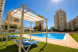 a swimming pool with two lounge chairs next to a building at Casa da Praia na Torre Castelo in Armação de Pêra