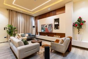 a living room with two couches and a tv at Luxe Haven in Lekki +10 photos
