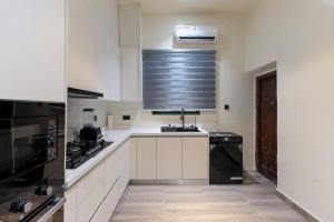 a kitchen with white cabinets and a black appliance at Luxe Haven in Lekki