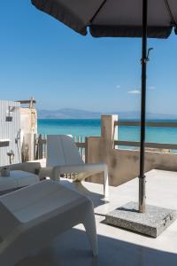 a patio with a table and an umbrella and the ocean at Sea Salt Studios in Nerántza