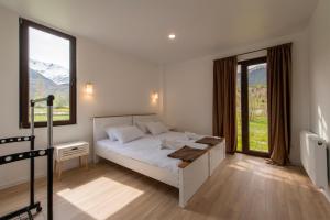 a bedroom with a bed and a large window at Sella Mestia in Mestia