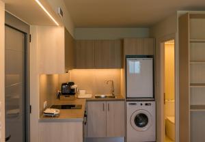 a kitchen with a sink and a washing machine at Sea Salt Studios in Nerántza